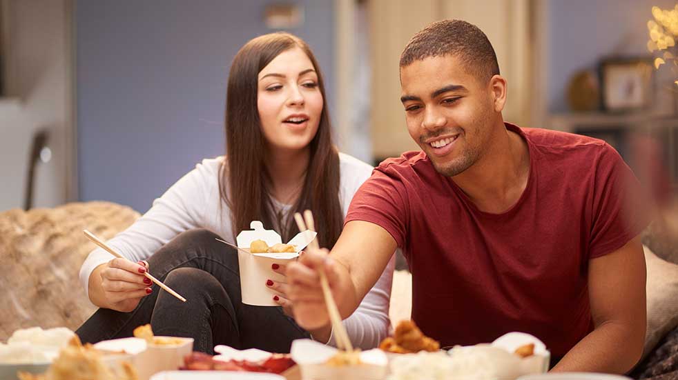 Deals for key workers young couple eating a takeaway